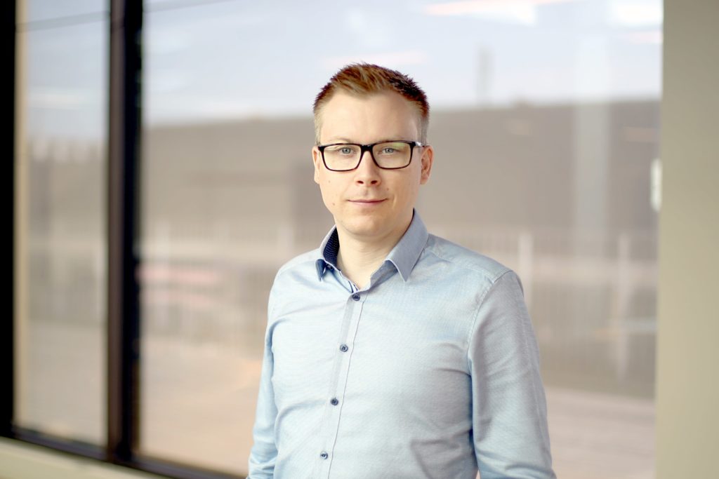 Et billede af en mand med blå skjorte og briller, der er Visma e-conomics finance director, Dennis Klitgaard